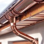 copper gutter with copper downspout and copper hangers