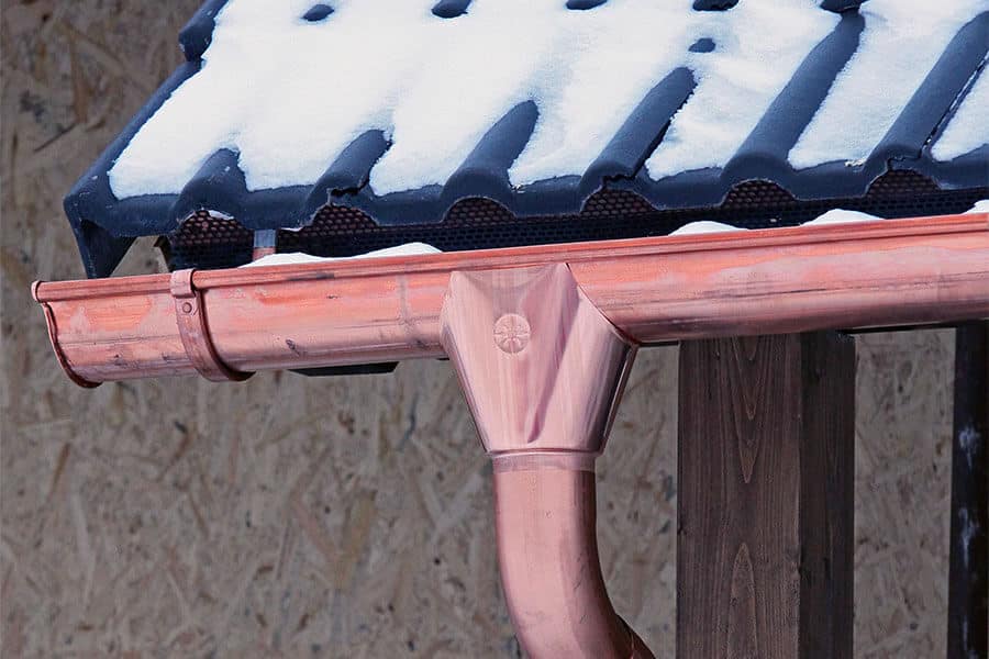 copper gutter copper leaderhead and downspout in winter